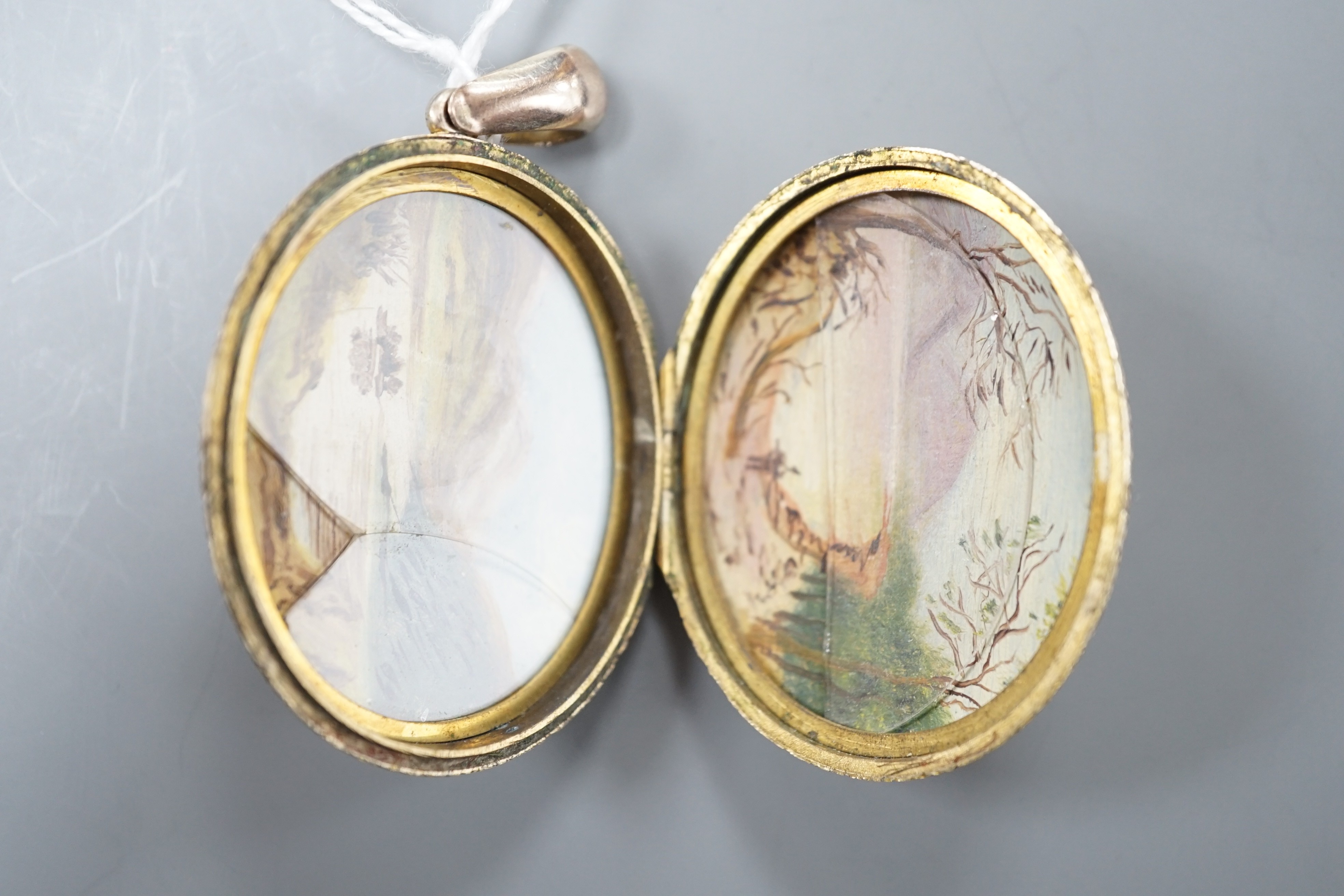 An engraved yellow metal overlaid oval locket, 46mm.